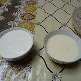 Две пиалы с белым кумысом на скатерти